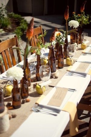 beer bottle centerpieces :) redneck meets classy w. the flowers! Prob wouldn&#39