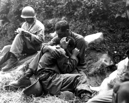 An American soldier comforts a fellow infantryman whose close friend has been ki