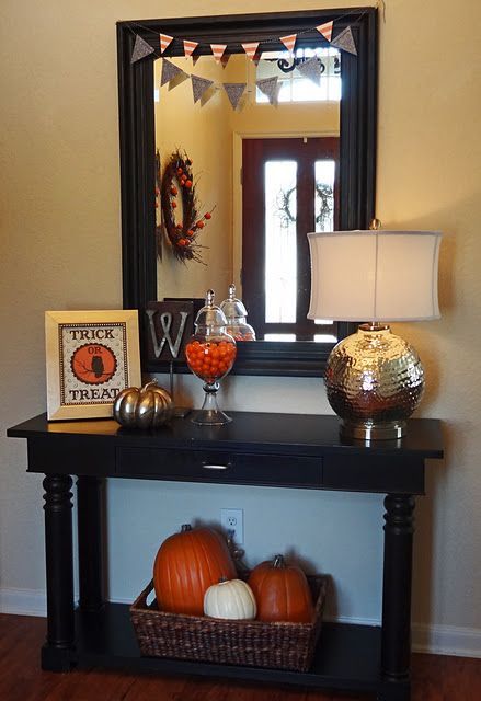 Pumpkins in a basket on bottom shelf of console table… Probably fake pumpkins.