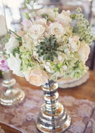Natural centerpiece with white and green flowers and succulents. Photo by Sarah