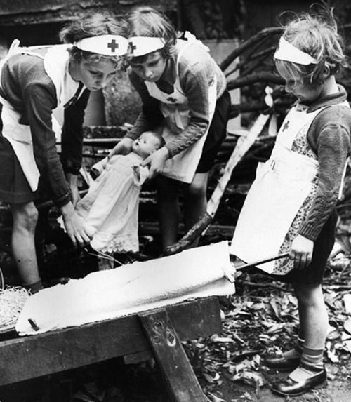 Children pretend to be nurses in the ruins of a bombed London, WWII.