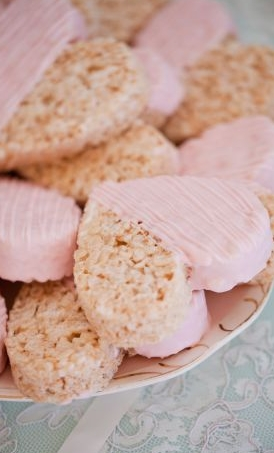 Heart shaped rice krispie treats dipped in pink white chocolate.