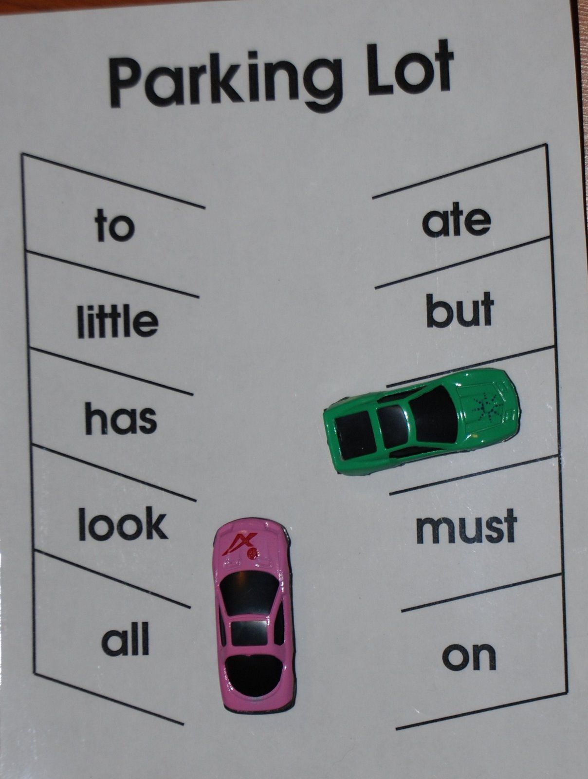 Call out a word and the kid drives their car and parks it on the correct word. F
