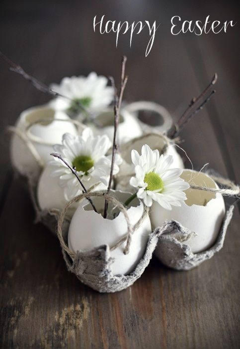 Different idea for an Easter centerpiece. Cute and spring-y eggshell vases in a carton, with daisy pompoms and twigs tucked in. See what other cute little seasonal flowers your florist