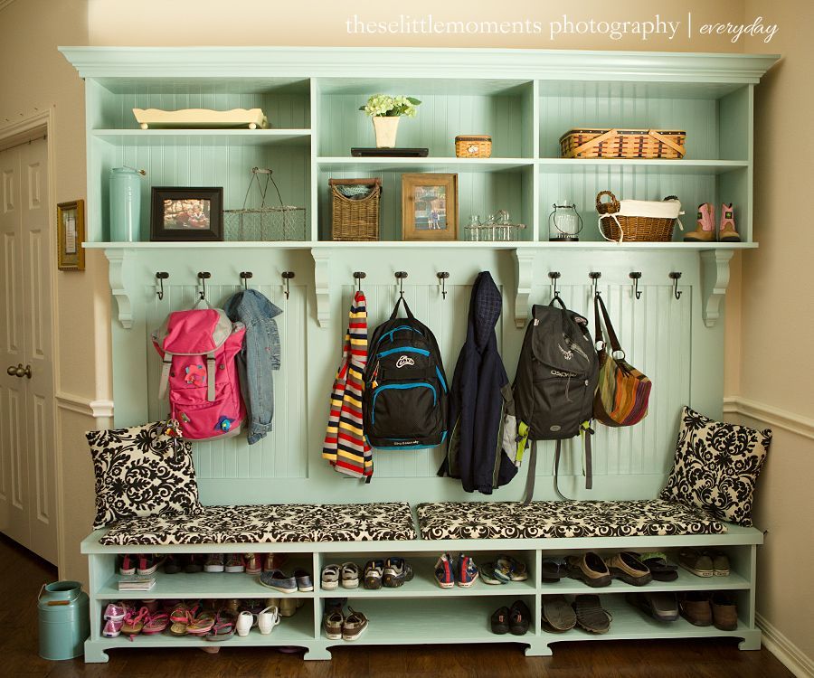Mudroom wall that has space for shoes, bench for sitting, hooks for coats and backpacks and storage