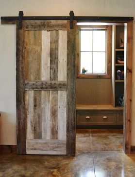 Sliding barnwood door to separate the mudroom from the rest of the home, custom made by Burchette.  Stained concrete flooring with