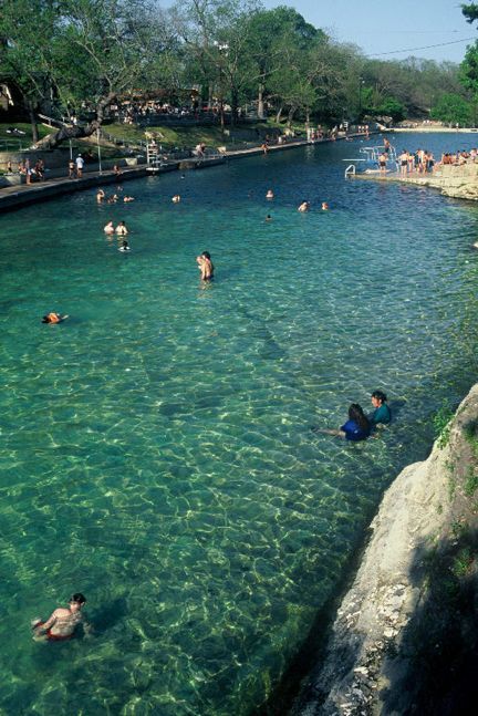 The cool water of Barton Springs pool invites people of all ages to swim and relax in Austins summer sun, and its 68 degrees year