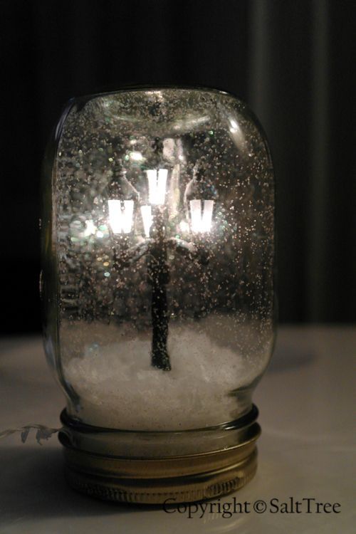 A pinner said, “OMG I HAVE TO MAKE THIS.  Mini lamppost snow globe how-to. Its like Narnia in a jar!”
