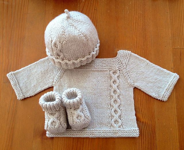 Jeudi – Top-down knitted baby sweater with raglan sleeves, back buttoning and a lovely off-center cable replicated on matching