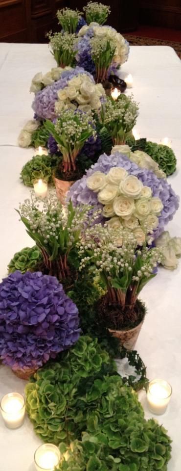 Lush & Beautiful purple & green flowers and candles table runner. Garden hydrangeas, potted lilies of the valley and perfect store