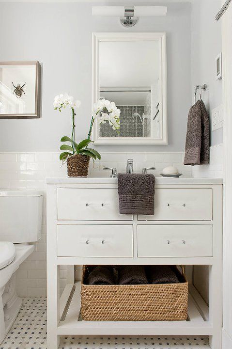 Clean and classic bathroom with pale gray walls, white subway tile backsplash and marble basketweave tiles floor. Restoration