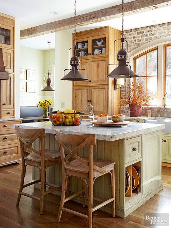 Rustic elements add layers of warmth that complement this kitchen’s natural wood cabinetry and green glazed finishes.