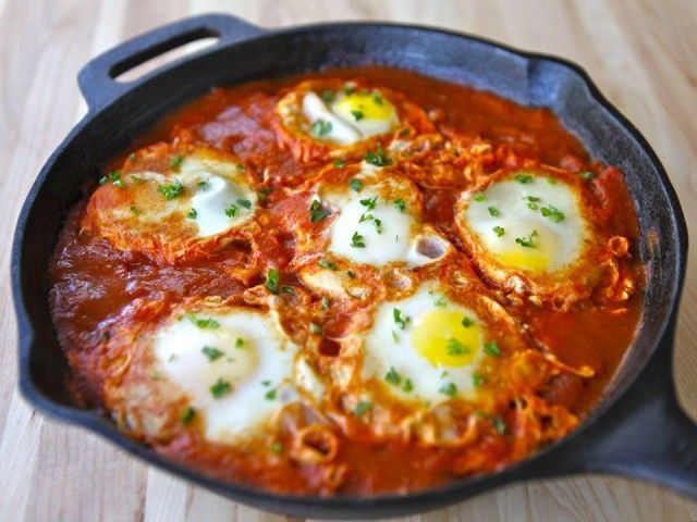 Shakshuka This is a simple, comforting Israeli dish of eggs poached in spicy tomato sauce. To make it, I sautee onions, garlic,