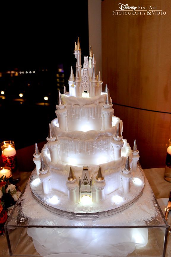 White Christmas wedding cake with Cinderella Castle topper, lights and sparkle