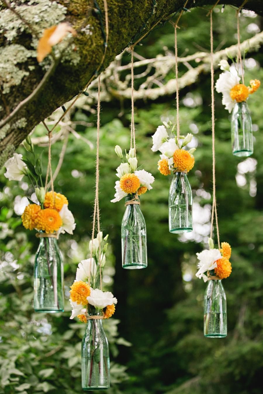 hanging flowers for outdoor wedding ceremony / reception decor. Suspend clear soda bottles from tree branc