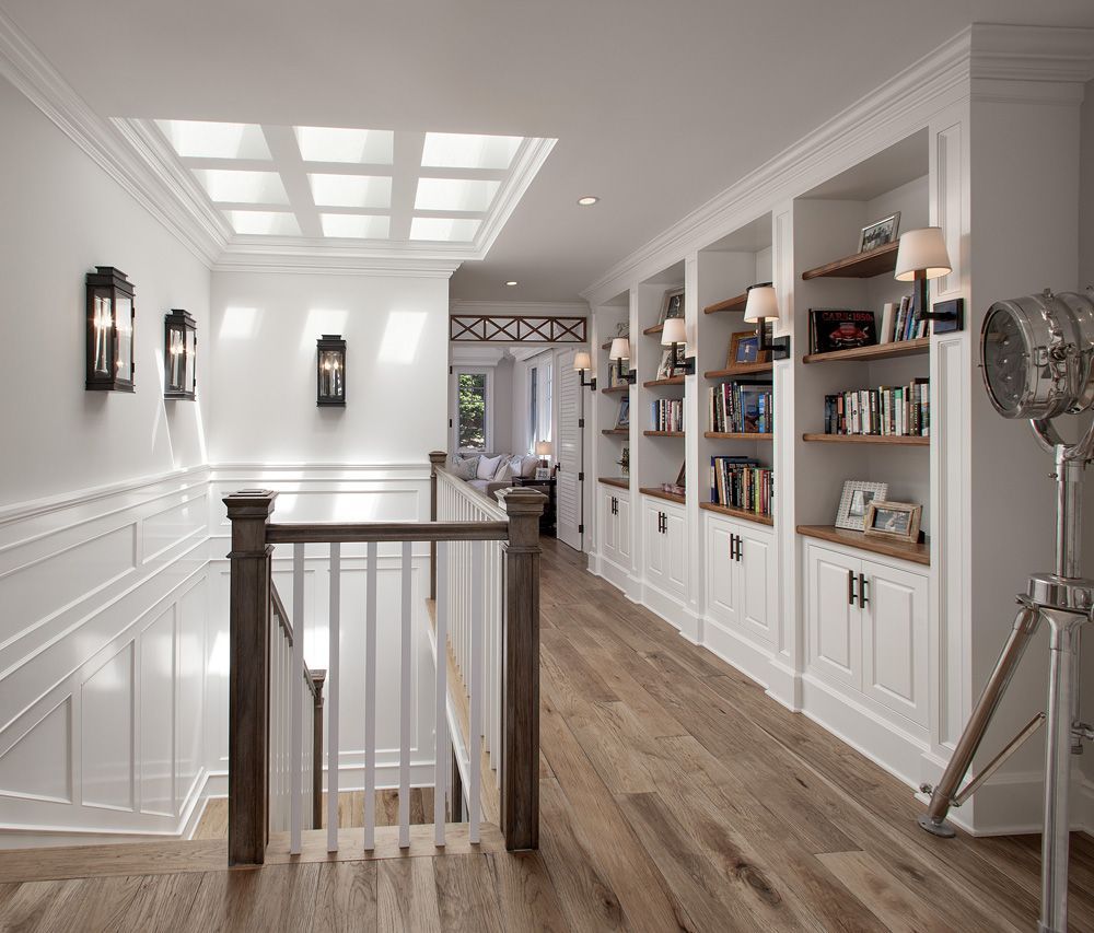 upper hallway, built in bookshelves, natural wood floors, skylights