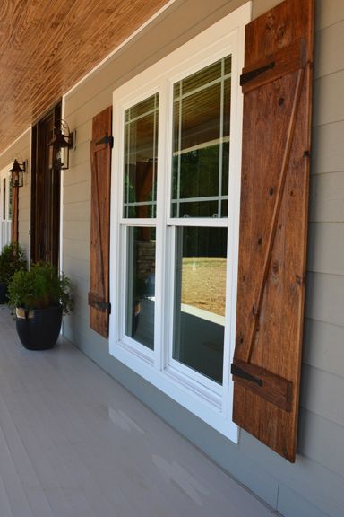 Front porch with custom ceiling, cedar posts, stone columns and wood shutters.