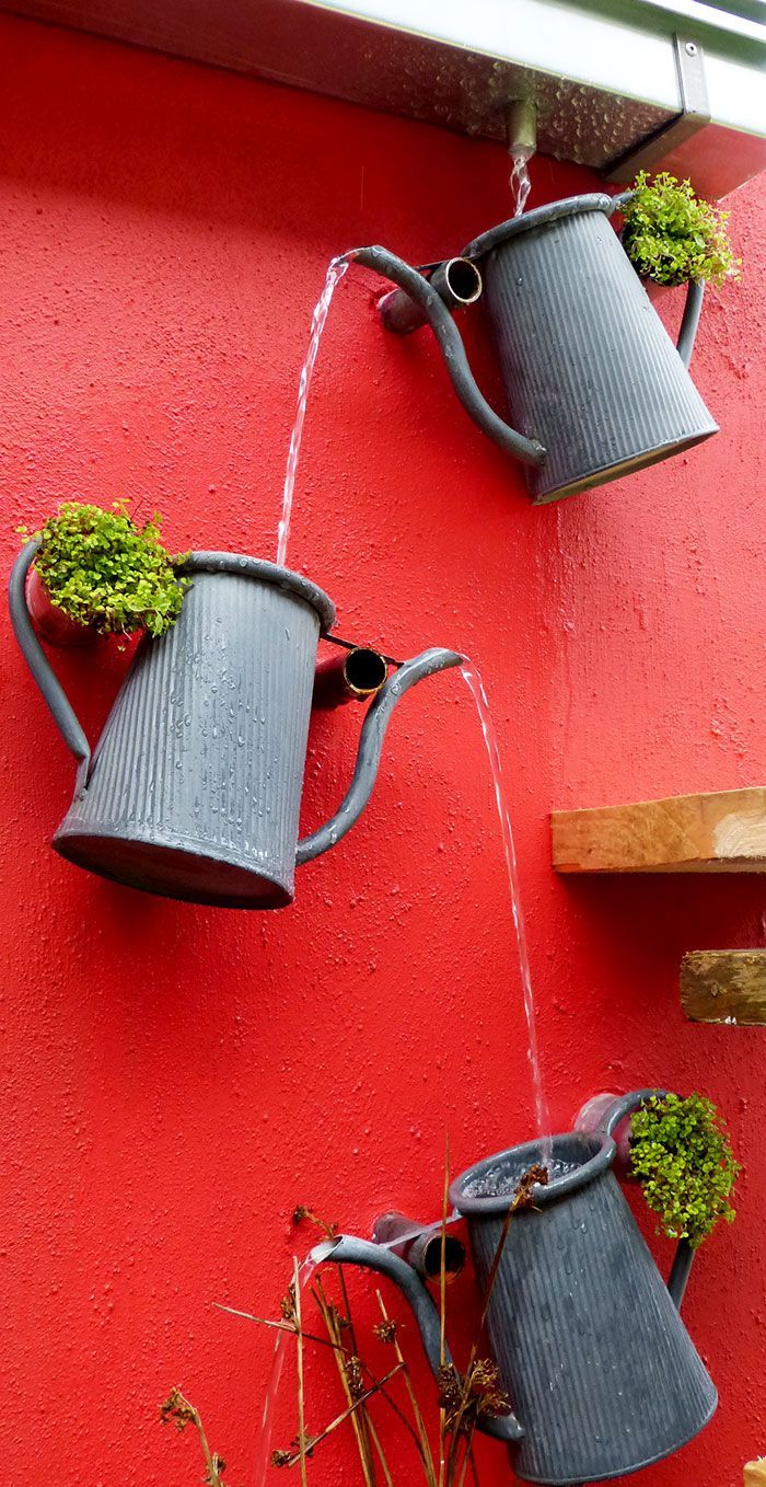 Fantastic cascading watering can feature. Great way to create a decorative drainage system from the gutter.