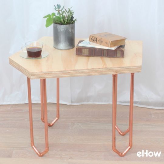 A simple geometric coffee table made of plywood and copper that stands on its own or fits together with others of its like.