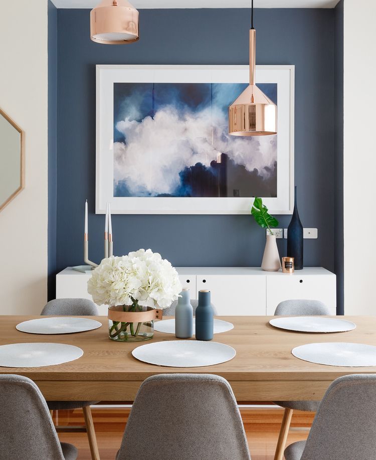 modern scandinavian style dining room with feature blue wall inset with white console, gold pendant lights, gray dining chairs,