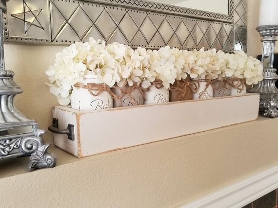 This is a farmhouse inspired long wood planter box. This is such a perfectly charming piece. The jars have been painted,