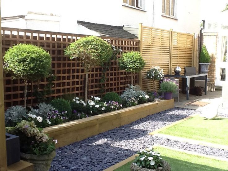 Raised sleeper border with trellis/standards/slate path/timber edge to lawn