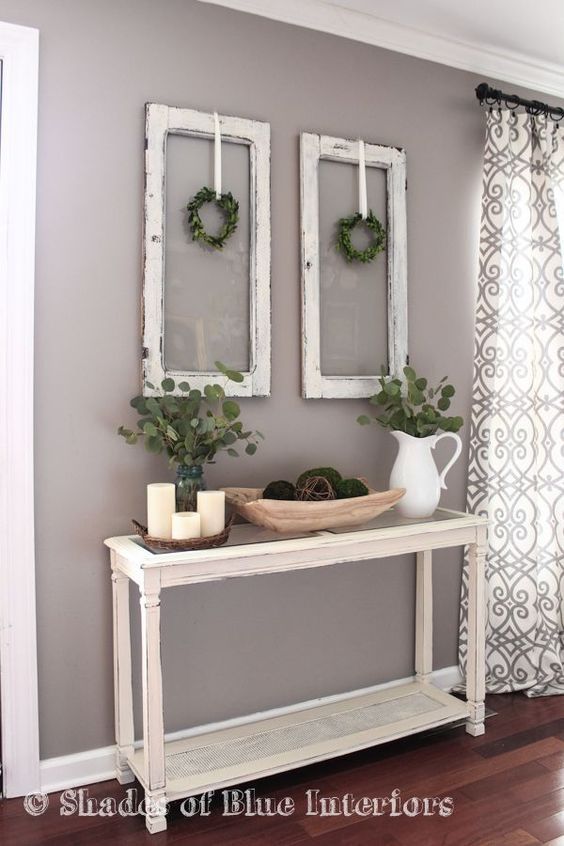 Living Room decor –  rustic farmhouse style with painted white console table, old window frames and simple greenery.