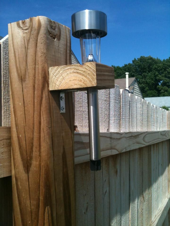 Fence Solar Lighting = 2×4’s cut to 2.5 inches long, drill 1 inch hole, attach to fence posts with “L” brackets, and drop the