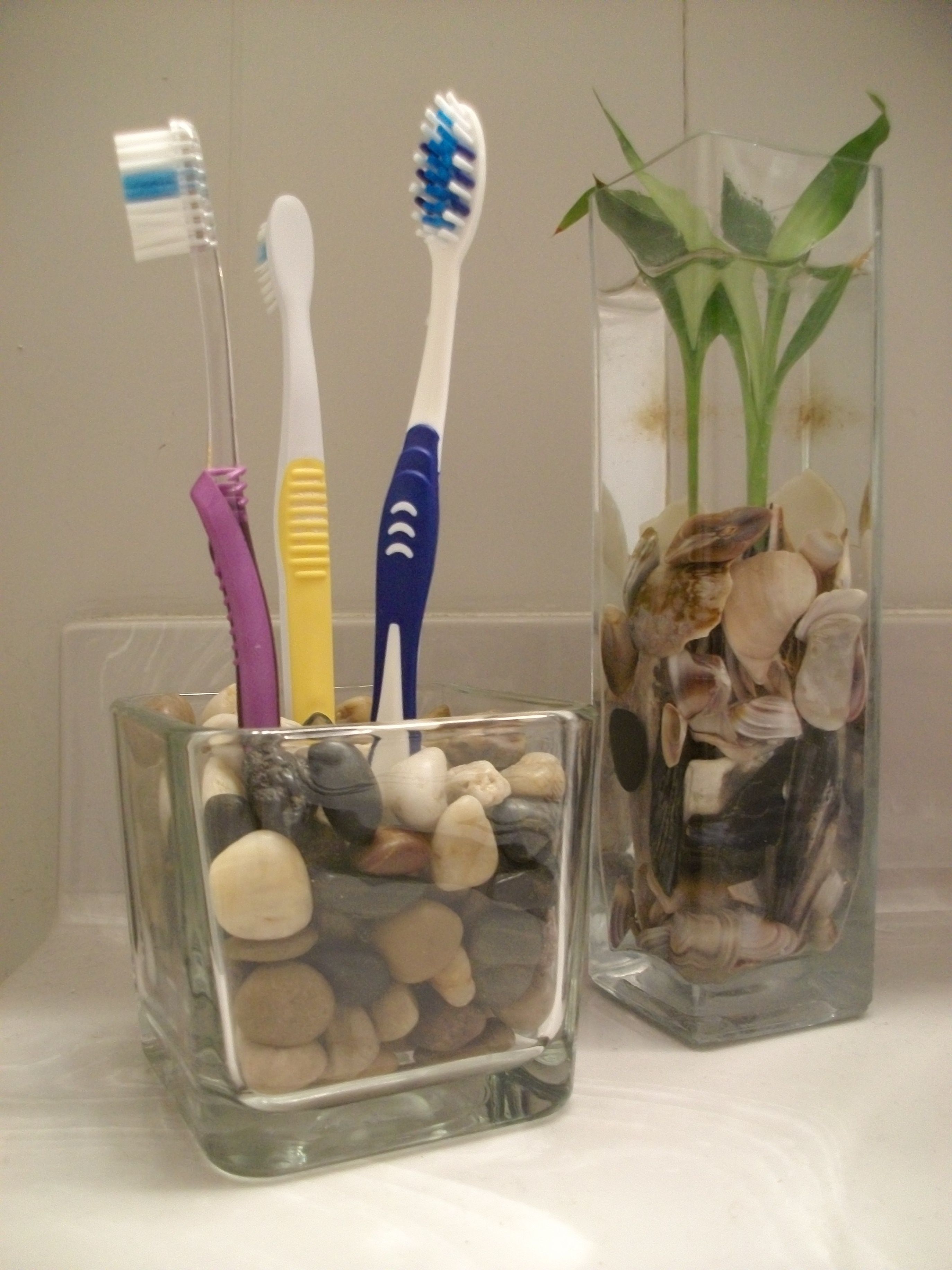 $2 Toothbrush Holder! At the Dollar Tree, purchase one glass candle holder or vase and one pouch of stones. I chose natural, but you can also choose glass beads to match the color of your bathroom! Simply place the stones into the vase and add toothbrushes! -   24 silver bathroom decor
 ideas