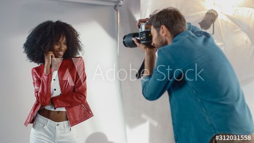 Attractive Black Girl with Lush Curly Hair Posing for a Fashion Magazine Photoshoot. Beautiful Girl Smiles during Professional Studio Photo Shoot for Fashion Magazine. Portrait Shot -   beauty Photoshoot magazine